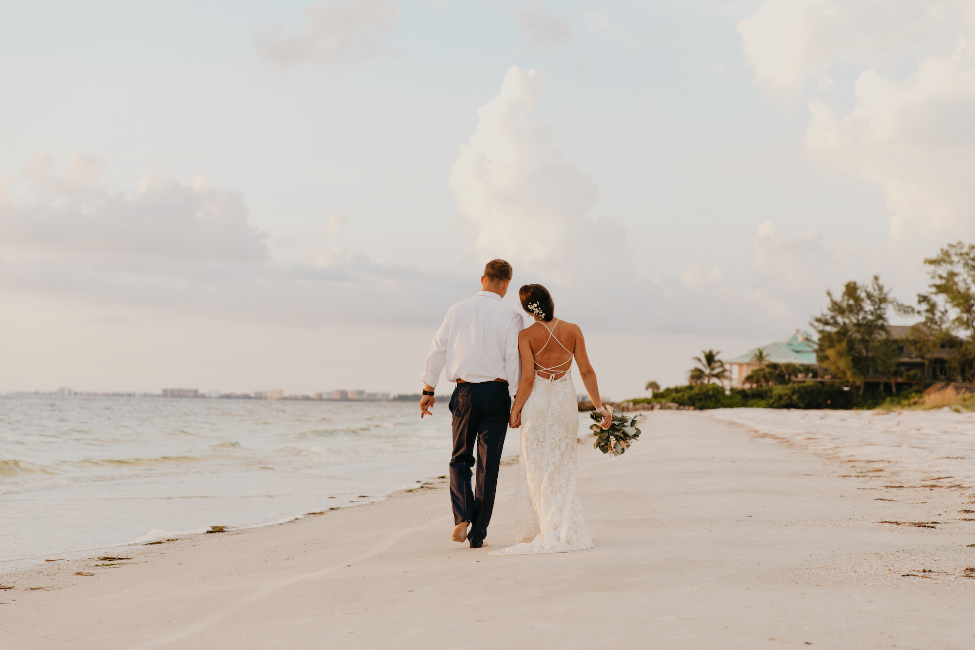 newly married couple walking on Seabrook Island beach